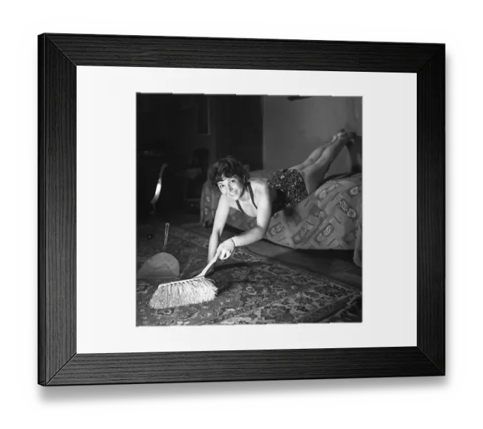 Framed Print : Woman of the 1940s. A woman is seen practising gymnastics while cleaning and dusting