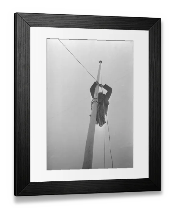 Framed Print : In the 1940s. A man making preparations on an arena for a game and installs electric lights Framed Print : In the 1940s. A man making preparations on an arena for a game and installs electric lights