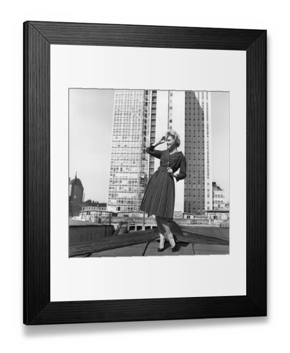 Framed Print : In the 1950s. A woman modelling a 1950s outfit with a jacket and skirt in matching dark