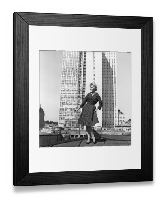 Framed Print : In the 1950s. A woman modelling a 1950s outfit with a jacket and skirt in matching dark