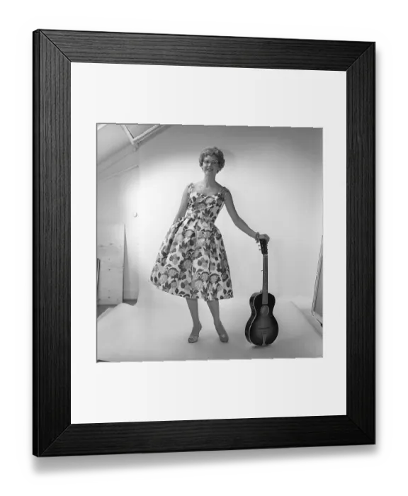 Framed Print : In the 1950s. A woman in the photographers studio wearing a dress patterned with flowers and leaves