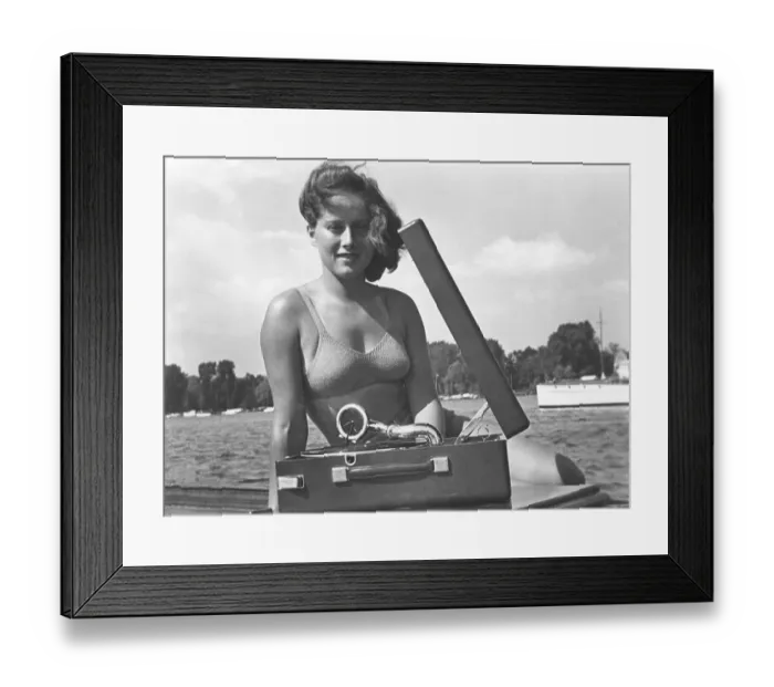 Framed Print : 1940s summer lifestyle. A young woman with a portable gramophone player on a summer's day