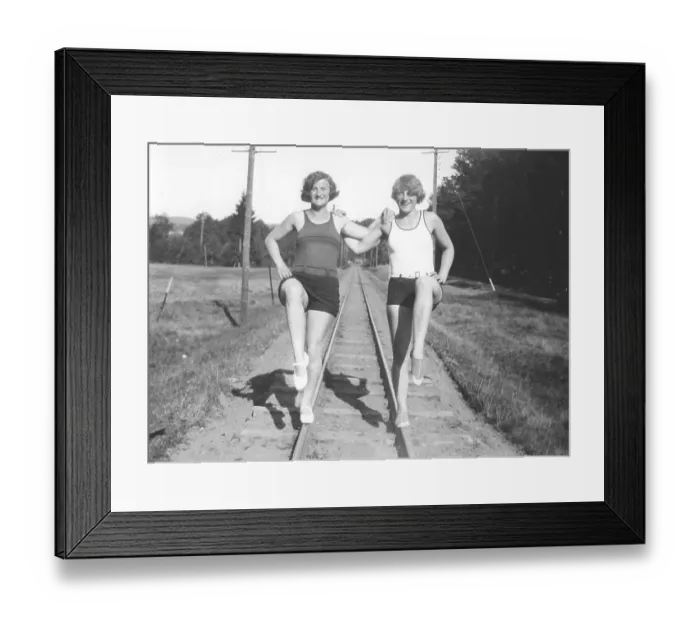 Framed Print : Fun in the 1930s. Two young women in bathing suits are balancing on the railway tracks Framed Print : Fun in the 1930s. Two young women in bathing suits are balancing on the railway tracks