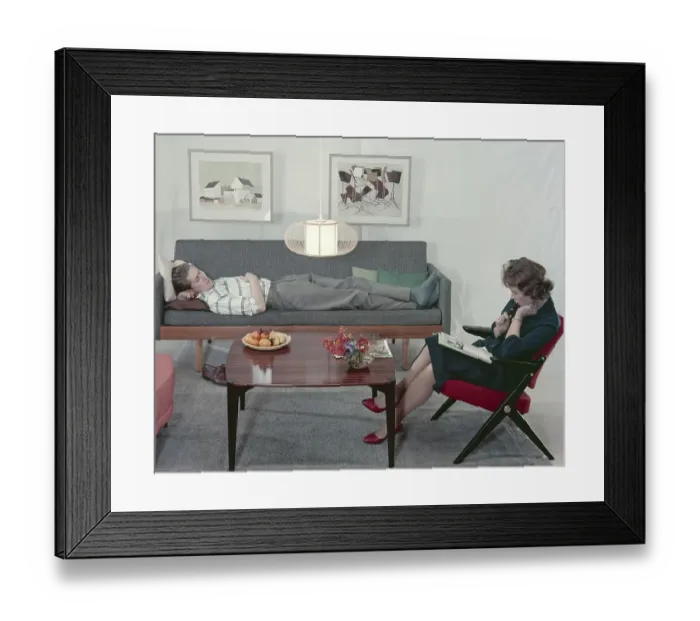 Framed Print : In the 1950s 1960s. A man and a women in a room with a couch and an armchair