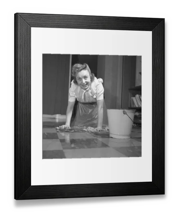Framed Print : Cleaning the floor back then. A young woman is lying on the floor and is scrubbing to get the floor clean