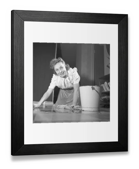 Framed Print : Cleaning the floor back then. A young woman is lying on the floor and is scrubbing to get the floor clean Framed Print : Cleaning the floor back then. A young woman is lying on the floor and is scrubbing to get the floor clean