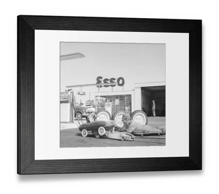 Framed Print : Service station of the 1950s. A boy in his pedal car has it serviced at an Esso petrol station Framed Print : Service station of the 1950s. A boy in his pedal car has it serviced at an Esso petrol station