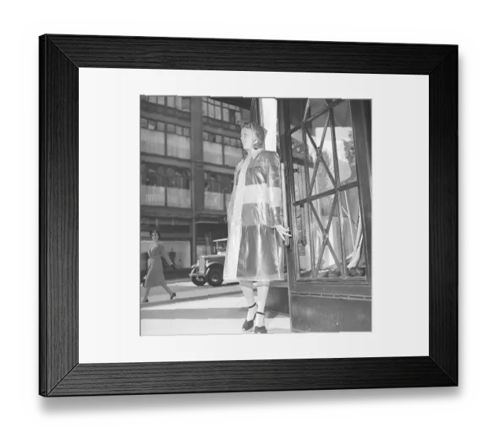 Framed Print : 1940s woman in raincoat. A young woman dressed in a raincoat of plastic material