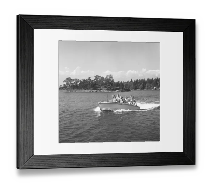 Framed Print : 1950s summer. A family passes the photographer in their small motor boat and waves happily Framed Print : 1950s summer. A family passes the photographer in their small motor boat and waves happily