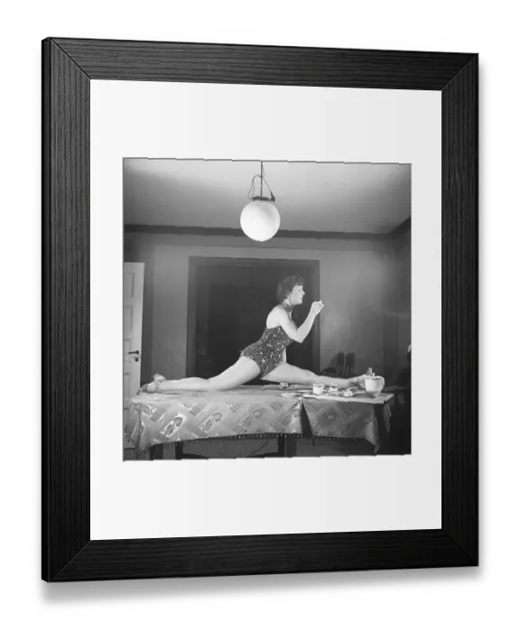 Framed Print : Woman of the 1940s. A woman is seen practising gymnastics while having a cup of coffee