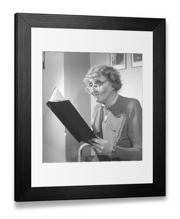 Framed Print : 1940s woman with glasses. An elderly lady with her glasses on her nose tip