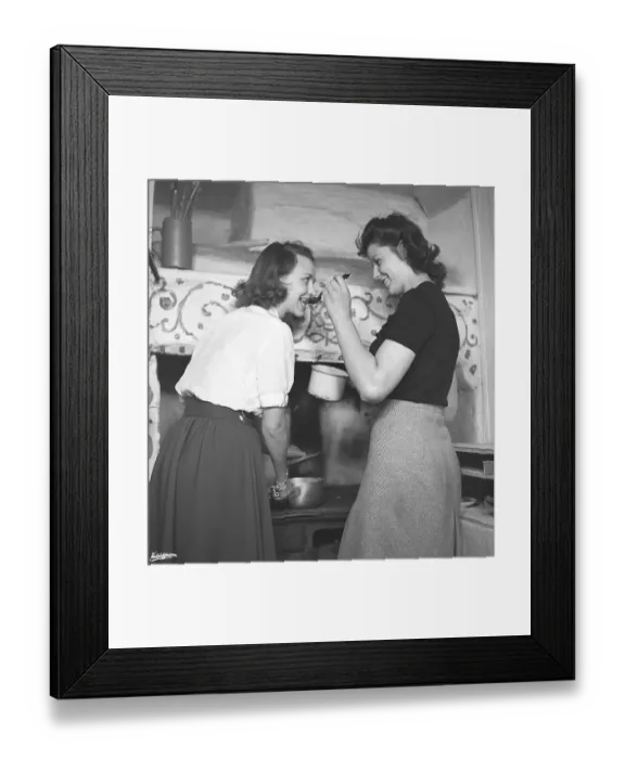 Framed Print : In the kitchen 1940s. Interior of a rural kitchen and two women cooking together
