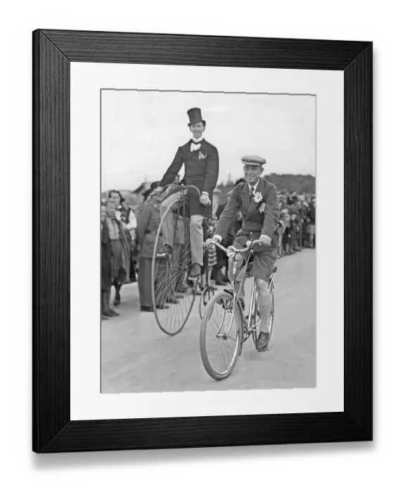 Framed Print : Penny farthing bicycle. A man is riding a penny-farthing bicycle besides a man on a regular bicycle