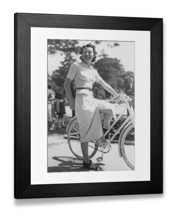 Framed Print : 1930s woman on a bicycle. A smiling young woman on a womens bicycle on a sunny day