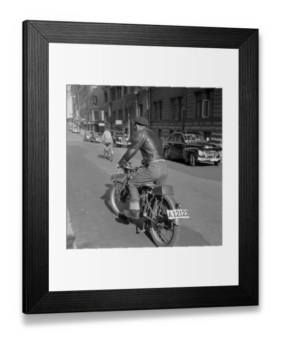 Framed Print : Motorcyclist in the 1950s. A young man on his motorcycle using the kick to start the engine Framed Print : Motorcyclist in the 1950s. A young man on his motorcycle using the kick to start the engine