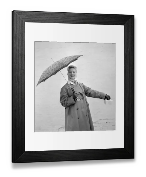 Framed Print : 1950s woman with umbrella. A young woman is holding an umbrella on a rainy day Framed Print : 1950s woman with umbrella. A young woman is holding an umbrella on a rainy day