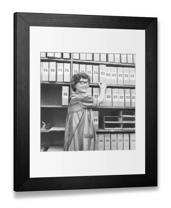 Framed Print : 1950s glasses. A young woman in glasses and bows August 1959 is working in an archive Framed Print : 1950s glasses. A young woman in glasses and bows August 1959 is working in an archive