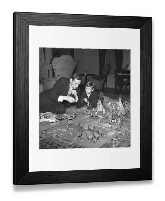 Framed Print : Toys in the 1940s. A man and his son on the floor playing with figures of cowboys and american indigenous people