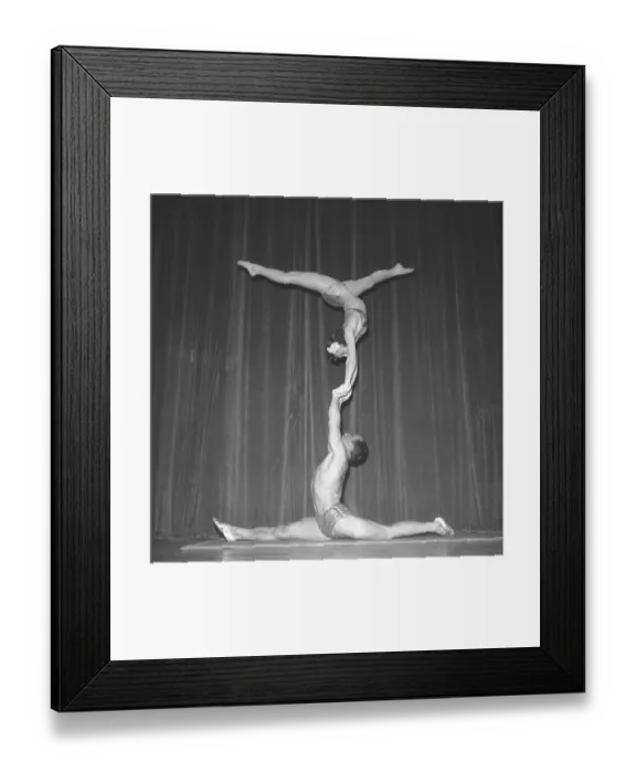 Framed Print : 1940s acrobatic show. The three acrobats practice their balance act behind the stage prior the performance on stage