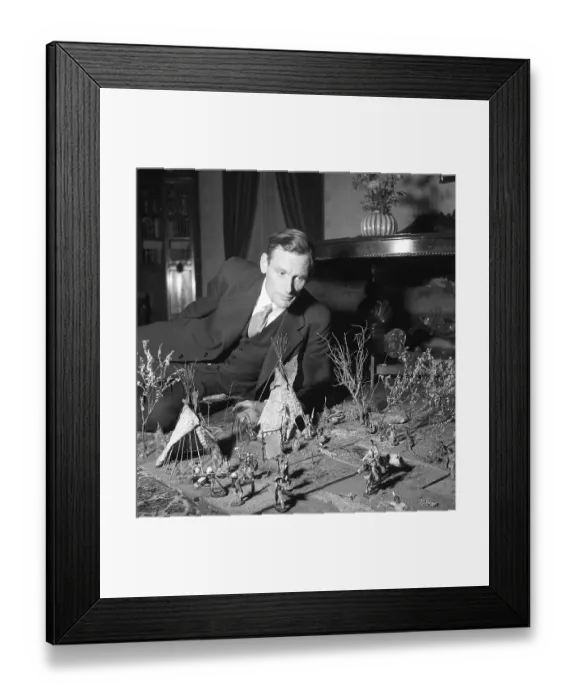Framed Print : Toys in the 1940s. A man on the floor playing with figures of american indigenous people