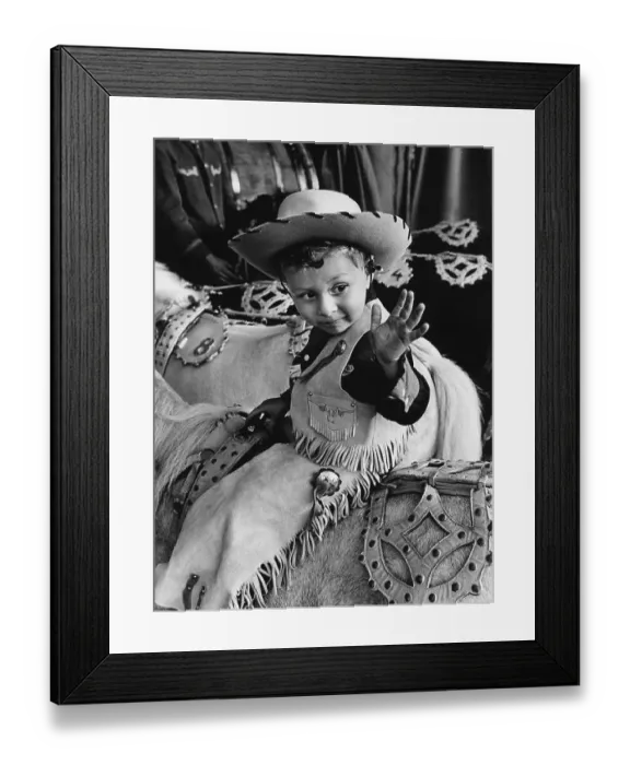 Framed Print : In the 1960s. A boy on a horse dressed in cowboy clothes and hat Framed Print : In the 1960s. A boy on a horse dressed in cowboy clothes and hat