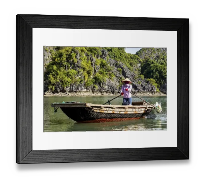 Framed Print : A fisherman calmly rows his boat along a green Framed Print : A fisherman calmly rows his boat along a green