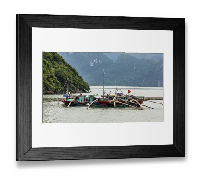 Framed Print : Fishing boats with Vietnamese flag resting on calm water