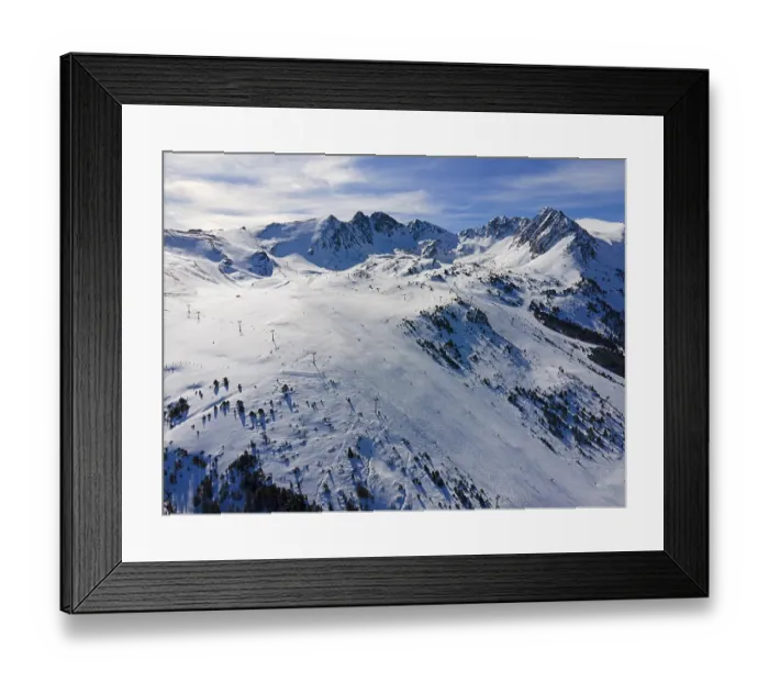 Framed Print : Aerial view of a snow-covered ski resort with mountains in the background Framed Print : Aerial view of a snow-covered ski resort with mountains in the background