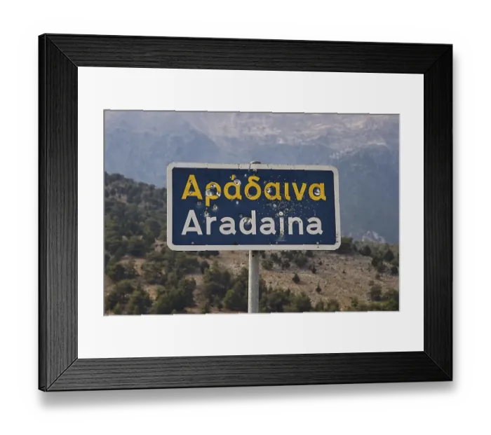 Framed Print : Damaged road sign with Greek and Latin lettering in front of a mountain landscape