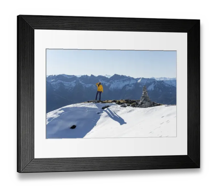 Framed Print : Mountaineer looks over snow-covered mountains