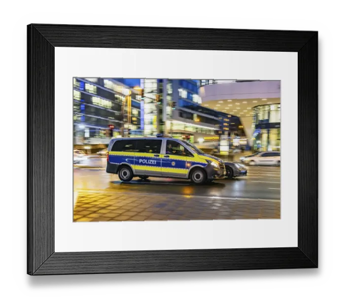 Framed Print : Police car in front of modern architecture of the city centre in the evening