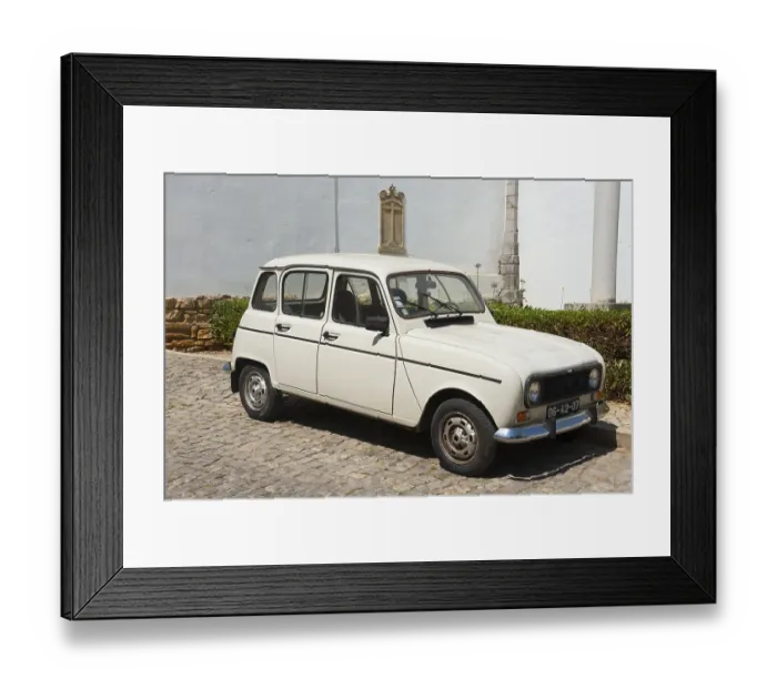 Framed Print : White vintage car on cobblestones in front of a historic building