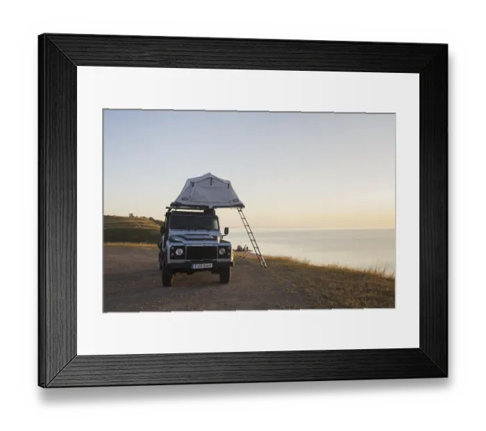 Framed Print : Off-road four-wheel drive vehicle with rooftop tent camping along the Baltic Sea at sunrise in summer