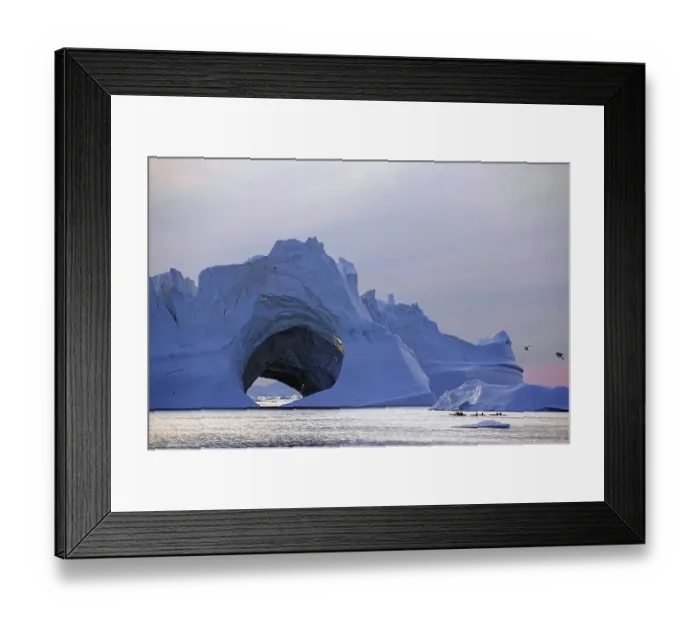 Framed Print : Kayaks in front of huge iceberg with cave