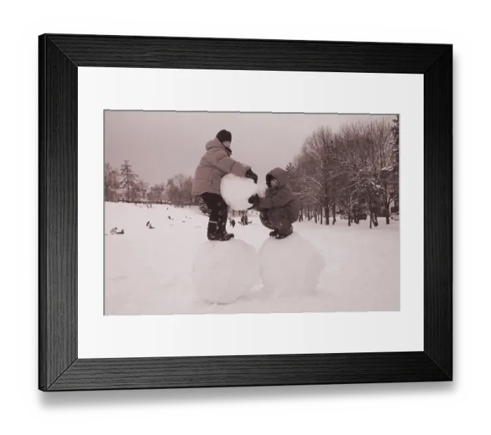 Framed Print : Two boys standing on big snoww balls