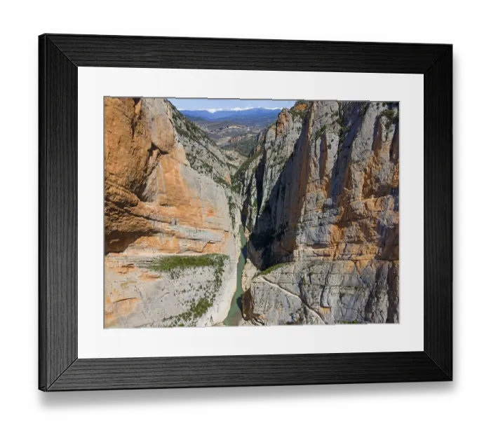 Framed Print : An aerial view of a narrow gorge with steep rock faces and a river flowing through the valley Framed Print : An aerial view of a narrow gorge with steep rock faces and a river flowing through the valley