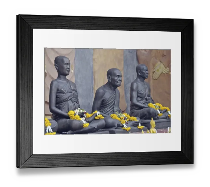 Framed Print : Statues of monks decorated with garlands of flowers