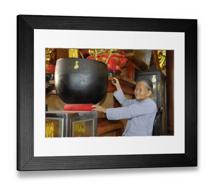 Framed Print : Old woman hitting a sound bowl