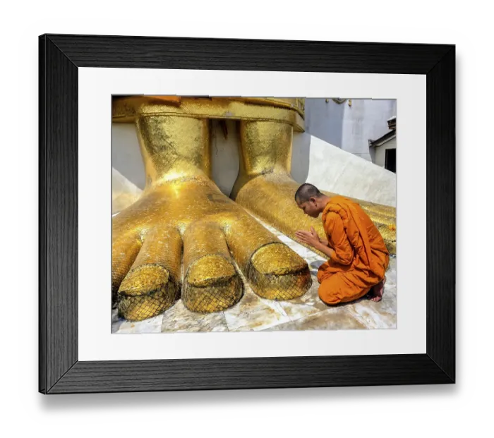 Framed Print : Monk praying at the feet of the golden Buddha statue of Wat Intharawihan