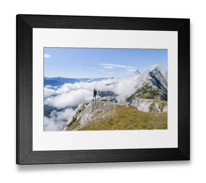 Framed Print : Hiker above the clouds, looking into the distance