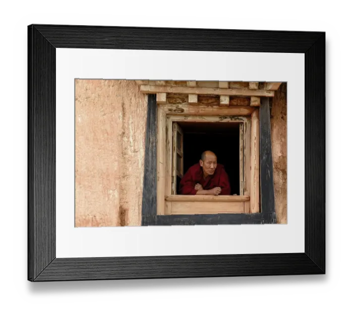 Framed Print : Elderly Tibetan monk looking out the monastery window of the Tibetan Buddhist monastery
