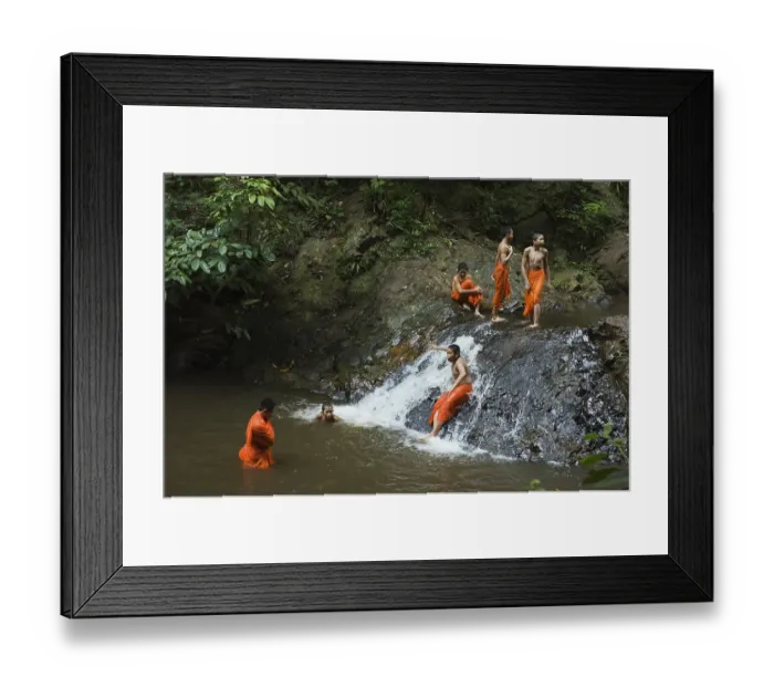 Framed Print : Buddhist monks having a bath in a waterfall in the jungle