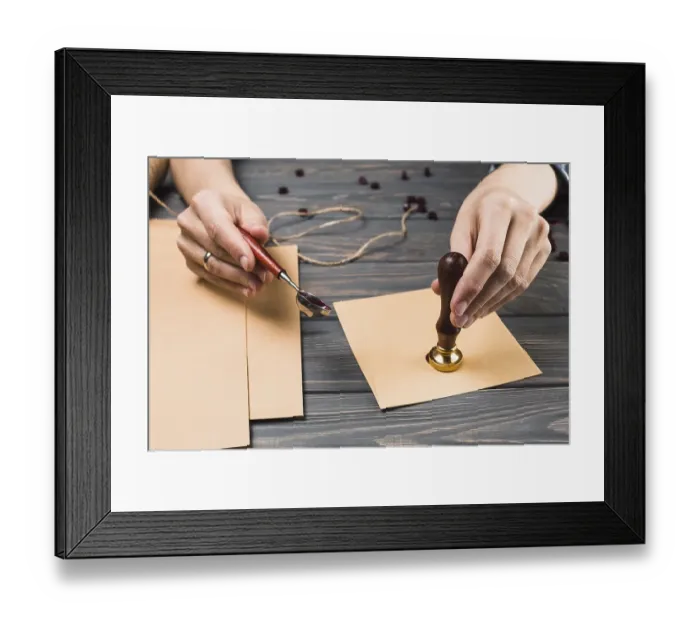 Framed Print : Womans hand sealing envelope with stamp