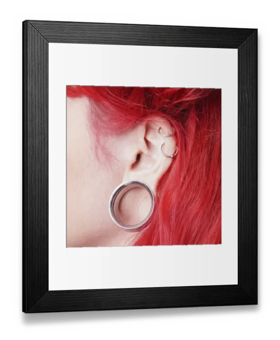 Framed Print : Stretched earlobe piercing with flesh tunnel