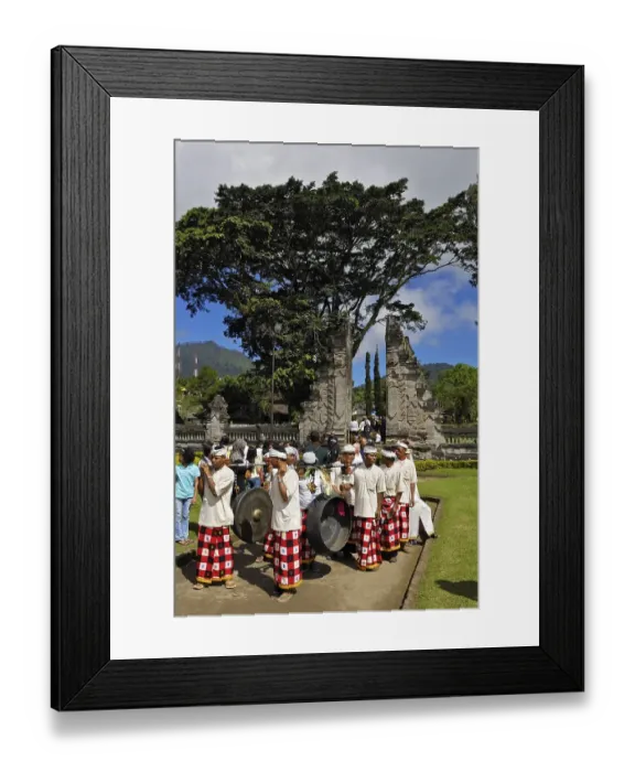 Framed Print : Musical band carrying two large gongs in front of the gate of Pura Ulun Danu Temple on Bratan Lake