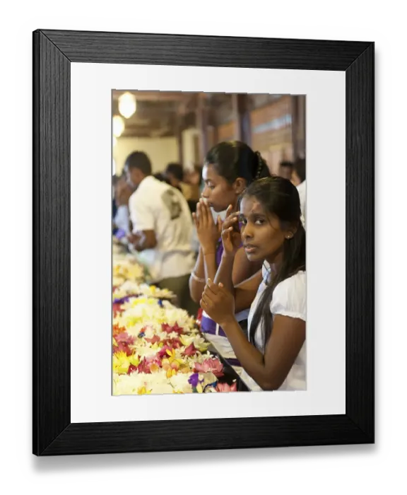 Framed Print : Praying young women sitting in front of flowers