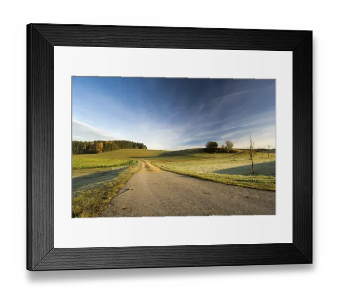 Framed Print : Road into a landscape of fields and woods
