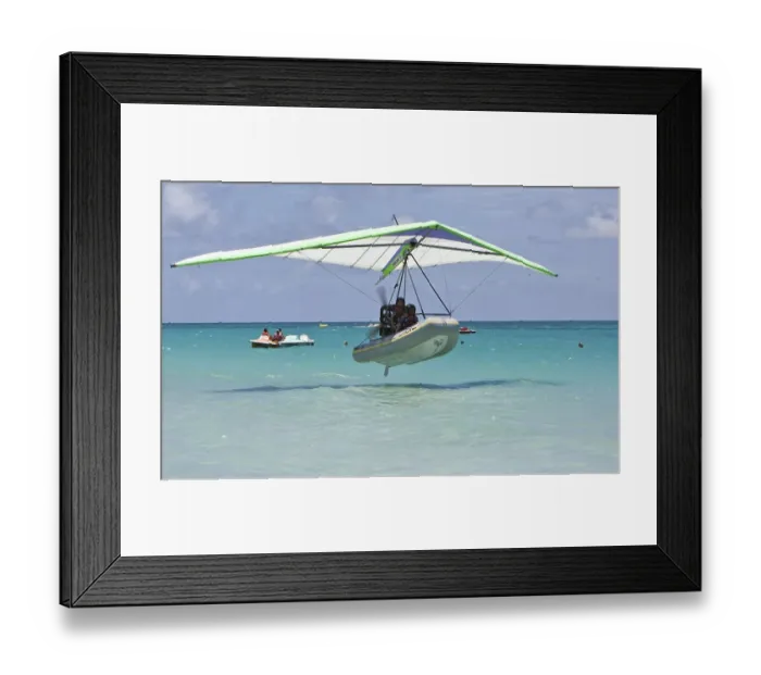Framed Print : Motorised hang glider landing on the sea