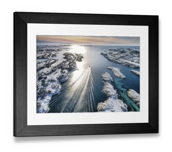 Framed Print : Motorboat sailing through a winter fjord landscape with small islands Framed Print : Motorboat sailing through a winter fjord landscape with small islands