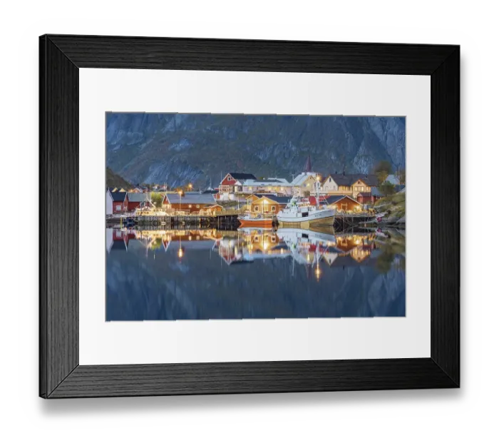 Framed Print : Wooden houses in the village of Reine are reflected in the twilight in the fjord